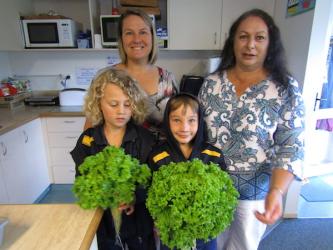 Students show lettuces to their teachers